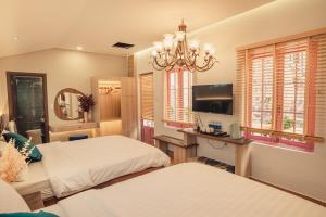 大叻Villa Hoa Da的一间卧室设有两张床、一台电视和窗户。