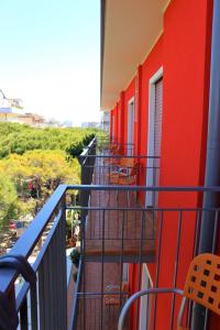 利多迪耶索罗Hotel Neps的阳台,建筑有红色的墙壁和椅子