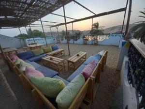 阿斯旺BAYT ZAINA - Nubian hospitality house的海滩上的一组沙发和枕头