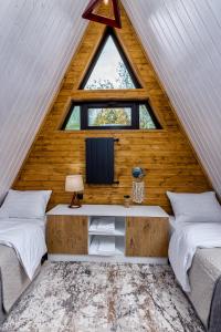 姆茨赫塔Modern Wood Cottages的客房设有两张床、一个窗户和电视。