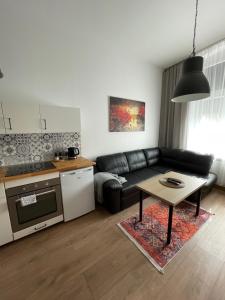 奥斯特罗达Mini apartament Ostróda的客厅配有黑色沙发和桌子