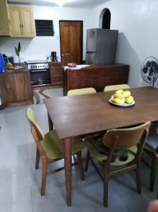 伊洛伊洛Cozy 1-bedroom house in quiet residential village.的厨房配有木制餐桌和椅子