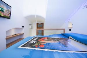 阿马尔菲La dimora del nonno...nel cuore di Amalfi的一间卧室配有一张蓝色的床,上面有杂志