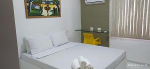 累西腓No coração de Boa Viagem的一张白色的床,位于一个黄色椅子的房间