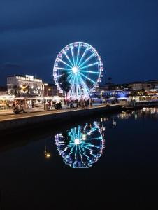 戛纳Ferretti 36 ' Bateau à Quai Vieux-Port Cannes Festival La Croisette的摩天轮夜间在水中反射