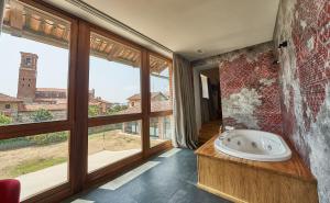 SandiglianoRELAIS CASCINA ERA的带浴缸的浴室和大窗户