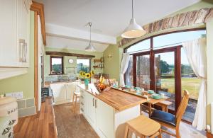 肯德尔Canny Brow Barn Garden Rooms的厨房配有桌子和大窗户