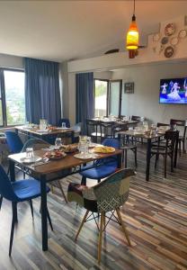 梅斯蒂亚萨克利拉哈姆什旅馆的餐厅设有桌椅和平面电视。