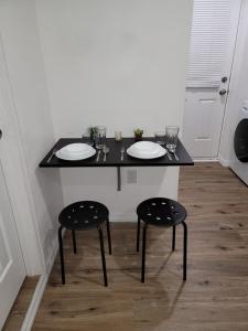 奥兰多Cozy studio apt的一张黑色桌子,上面有两把椅子和盘子