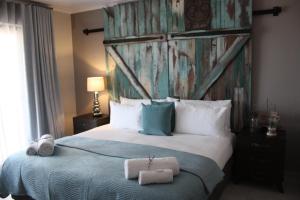 兰格班Rox and Sea Country Lodge的一间卧室配有一张大床和毛巾
