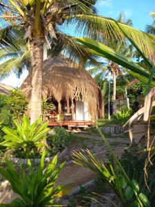 维兰库卢什Baobab Beach Vilanculos的一间棕榈树小屋和一张桌子