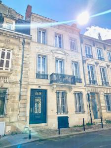 波尔多B&B La Maison Galiène的街道上一座带绿门的大型石头建筑