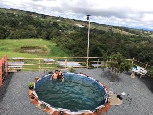 弗洛伦西亚CAMPING LOS ROBLES POPAYÁN的两人坐在一个大水池里