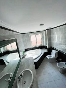 卡萨布兰卡Beautiful Villa Casablanca的一间带两个盥洗盆、浴缸和卫生间的浴室