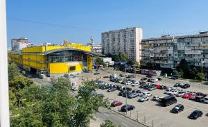 基辅Квартира напротив Дрим-Тауна的停车场,有黄色的建筑和停车场