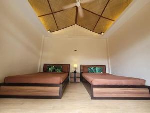 大雅台VYU PRIVATE VILLA - TAGAYTAY的天花板客房内的两张床