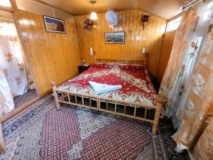 斯利那加Tashkand Houseboat的一间小卧室,配有一张位于木制房间内的床