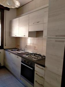 斯嘉德瓦利Casa nel Delta del Po的厨房配有白色橱柜和炉灶烤箱。