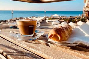 热那亚MOONLIGHT IN BOCCADASSE (cod.Citra:010025-LT-2349)的一张桌子,上面放着咖啡和羊角面包