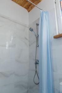 皮什Domki Snopki的浴室内配有蓝色淋浴帘