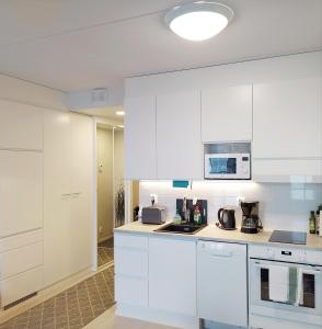塞伊奈约基Lovely new city apartment all amenities的厨房配有白色橱柜和微波炉