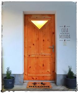 TrinCasa Mirada的白色建筑中木门,有两盆植物