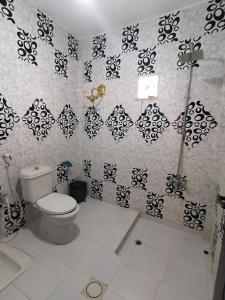 瓦迪穆萨Petra paradise home的浴室设有卫生间,配有黑白墙纸