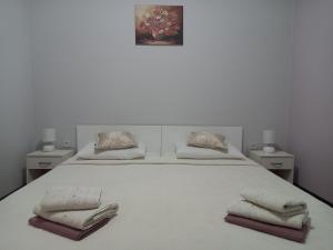 卡什泰拉Apartman Maja的一张白色的床,上面有两条毛巾
