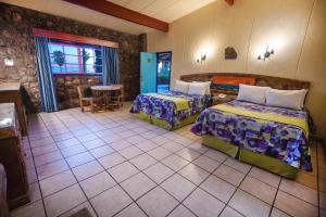 洛雷托绿洲酒店的酒店客房设有两张床和一张桌子。