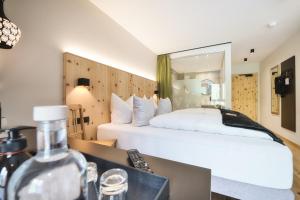 圣安东阿尔贝格Hotel die Arlbergerin ADULTS FRIENDLY 4 STAR的卧室配有一张白色大床和镜子