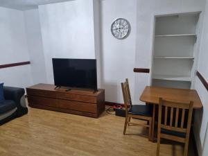 阿伯丁Homie的客厅配有电视、桌子和时钟