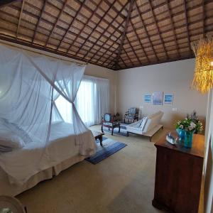 科鲁里皮Coco Pontall Bangalôs的一间带天蓬床的卧室和一间客厅
