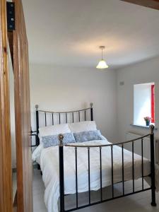 BellanagareThe Old Mill, Kilcorkey, Bellanagare, Castlerea, County Roscommon - West of Ireland的一间卧室配有一张带白色床单的床和一扇窗户。