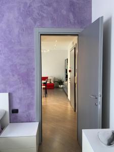 科洛尼奥蒙泽塞Petit place incantevole a due passi da Milano!的走廊通往带紫色墙壁的客厅