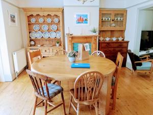 达特茅斯The Nautical Nest in the heart of Dartmouth的一间带木桌和椅子的用餐室