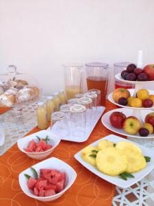 库斯托纳奇Orange Paradise b&b的一张桌子,上面放有水果盘和果汁杯