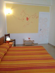 库斯托纳奇Orange Paradise b&b的一间卧室配有一张带橙色条纹床罩的大床
