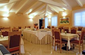 圣塞韦罗Hotel Palazzo Giancola的一间在房间内配有桌椅的餐厅