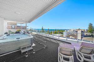 麦夸里港麦格理水域精品公寓式酒店的一个带热水浴缸和椅子的大阳台