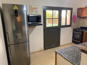 乌尼翁镇Casa - del TALAMPAYA的厨房配有不锈钢冰箱和微波炉。