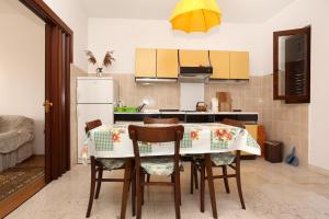 斯瑞瑟尔Apartments by the sea Sreser, Peljesac - 10206的厨房配有桌椅和冰箱。