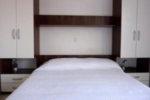 德雷斯Apartment Drace 10127b的一间卧室配有一张带白色床单和橱柜的床。