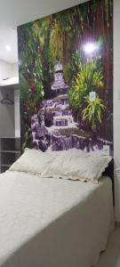 阿尔特杜尚CASA CONFORTÁVEL COM 4 QUARTOS EM ALTER DO CHÃO的瀑布画的房间里一张床位