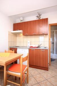 库希斯特Apartments by the sea Viganj, Peljesac - 10189的厨房配有木制橱柜和桌椅