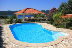 维甘Seaside family friendly house with a swimming pool Viganj, Peljesac - 10253的一座带房子的庭院内的游泳池