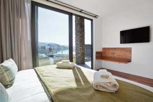 特卡波湖Grand Suites Lake Tekapo的酒店客房设有一张带大窗户的床。