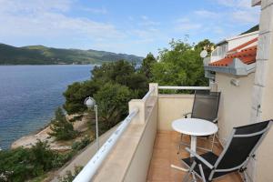 维甘Apartments by the sea Viganj, Peljesac - 10116的大楼内的阳台配有两把椅子和一张桌子