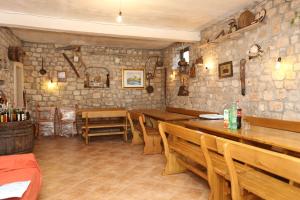 BrijestaApartment Brijesta 10223a的拥有木桌和椅子以及石墙的餐厅