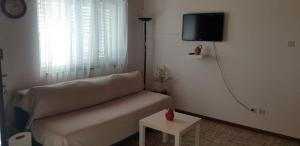 泰斯Seaside holiday house Nemira, Omis - 9504的客厅配有沙发和墙上的电视