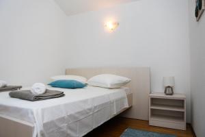 扎瓦拉提卡Family friendly house with a swimming pool Zavalatica, Korcula - 9476的一间卧室配有带白色床单和蓝色枕头的床。